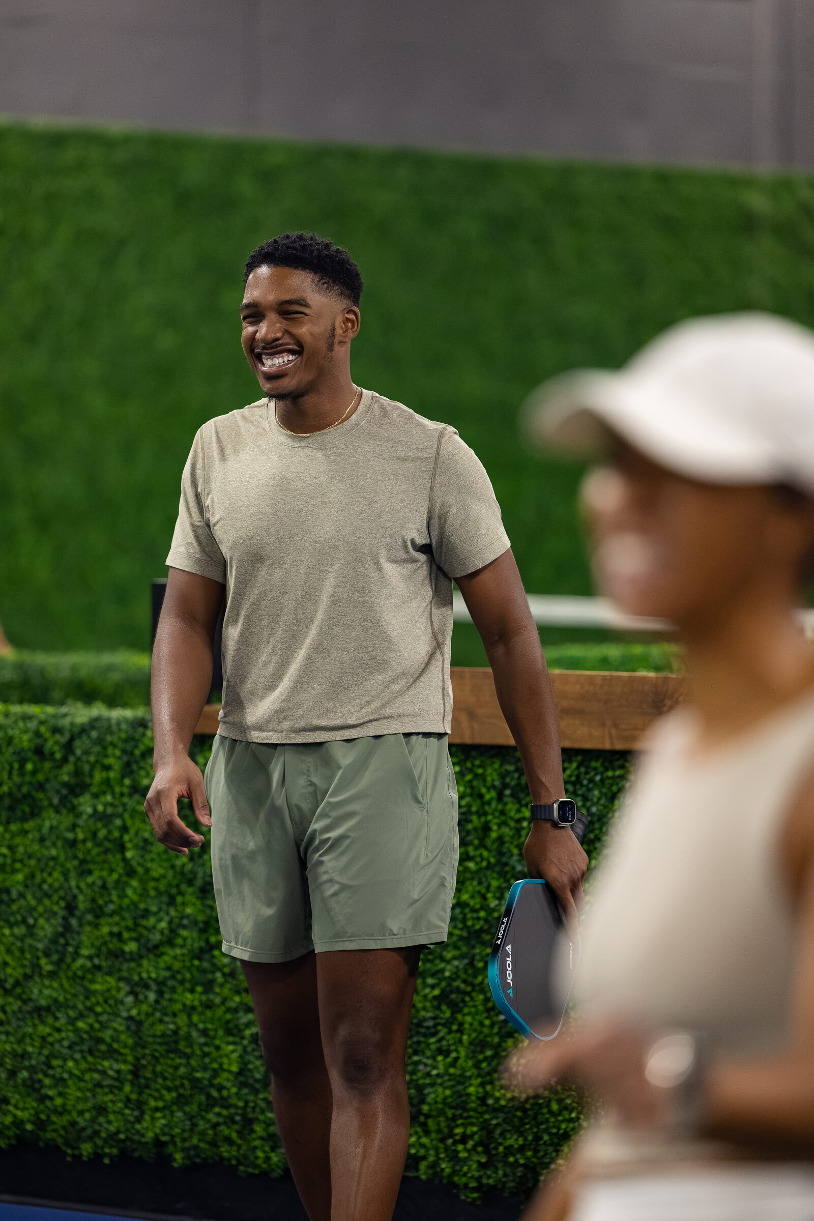 An attendee smiling courtside between points