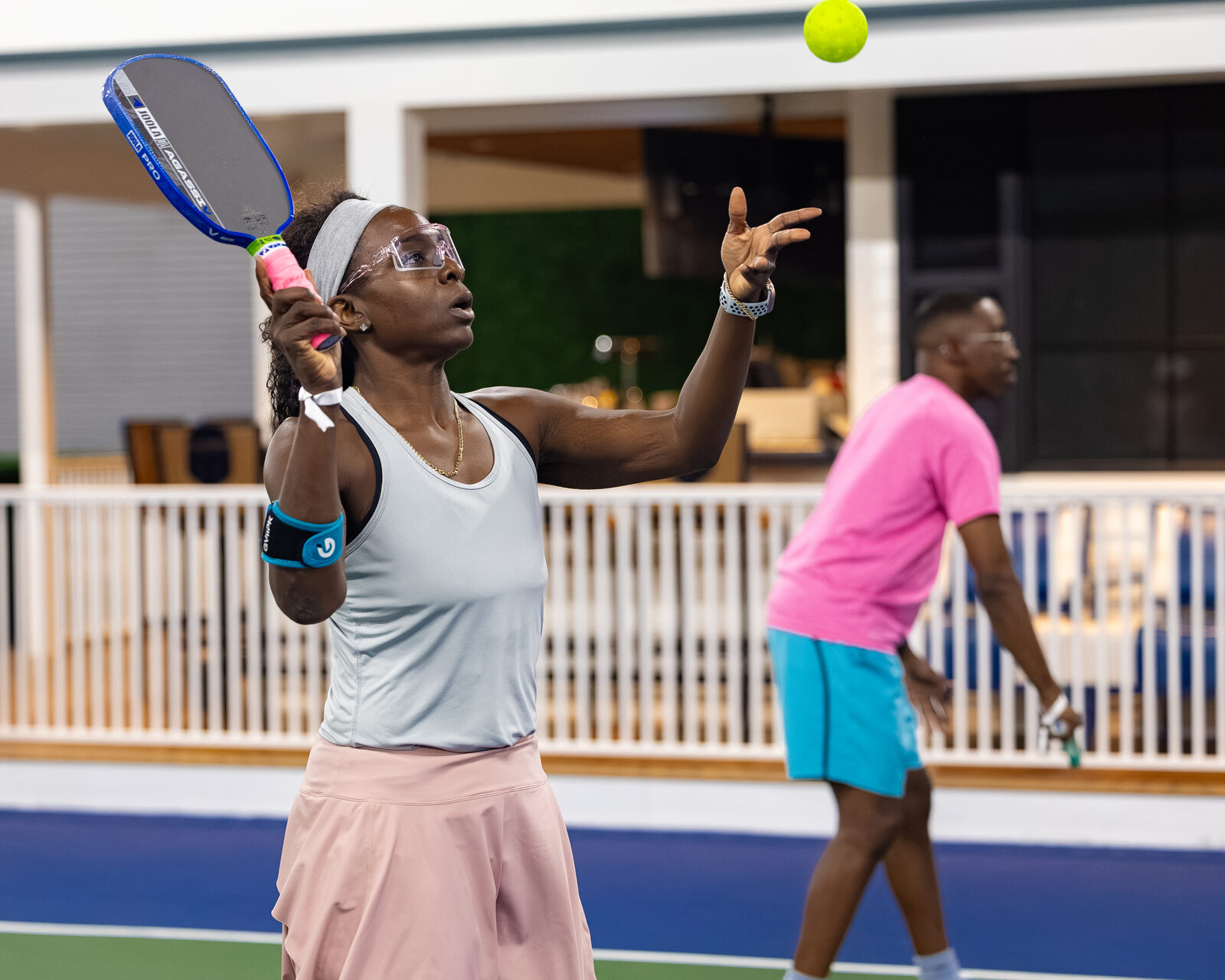 A player mid-serve, ball frozen in the air